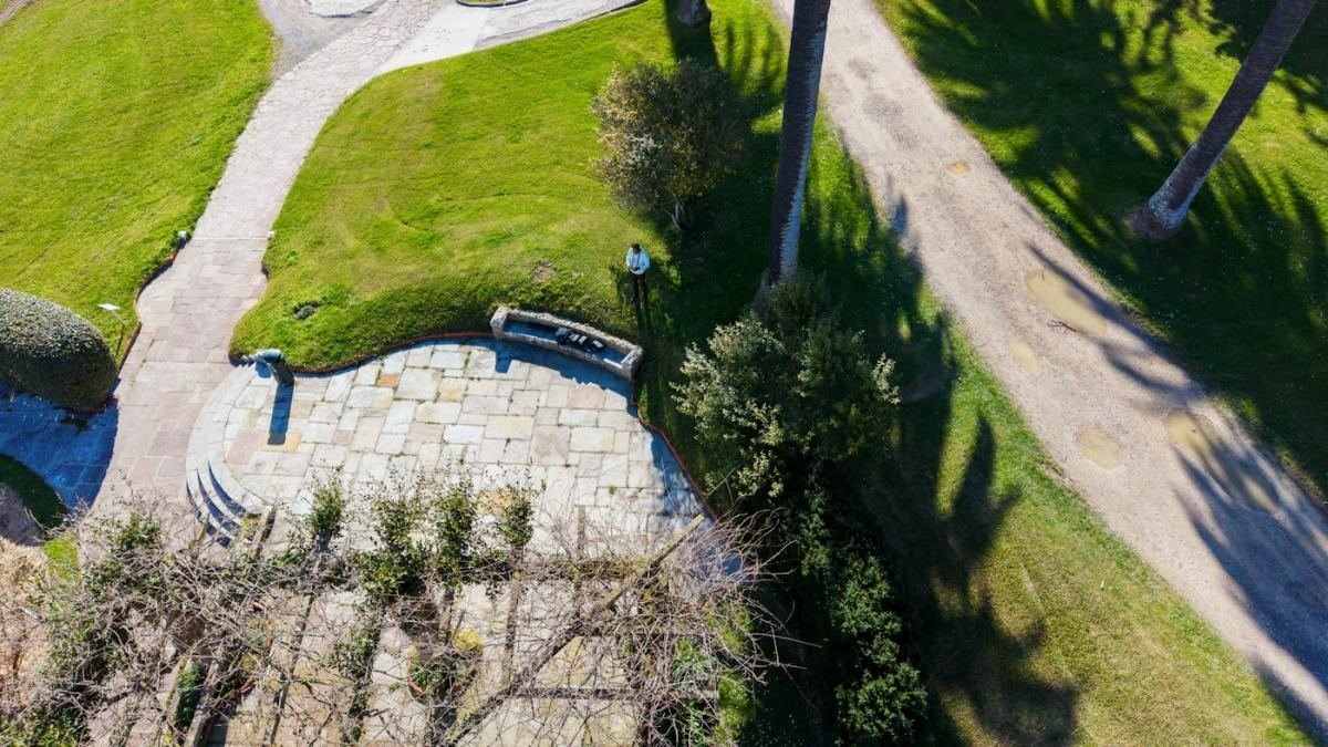 Manicured grounds with stone paving and clipped planting seen from above